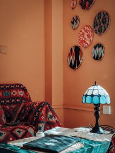 Habitación con sofá y mesa con lámpara. en New Dap Hostel (in Grape Town), en Turfan