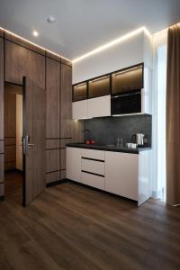 a kitchen with white and brown cabinets and wood floors at BonApart Maidan by UHM in Kyiv