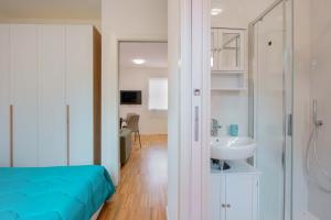 un bagno con un letto, un lavandino e uno specchio di Mascarella Apartments a Bologna Altre 55 foto