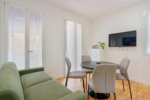 un soggiorno con un divano verde e un tavolo di Mascarella Apartments a Bologna