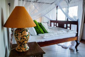 a lamp sitting on a table next to a bed at Amani House in Kilifi