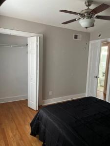 een slaapkamer met een zwart bed en een plafondventilator bij Chic 2BR Apt near Lenox Square! in Atlanta