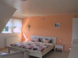 a bedroom with a bed with an orange wall at Unterfalkenhof in Schramberg