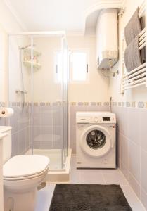 Un baño con inodoro y lavadora. en Hola Torrevieja, en Torrevieja