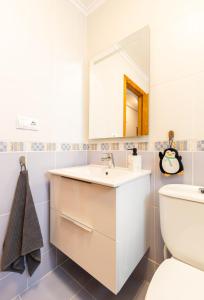 ein Badezimmer mit einem weißen Waschbecken und einem WC in der Unterkunft Hola Torrevieja in Torrevieja