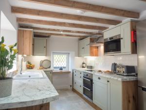 LlechrydにあるCilbronnau Lodge Cardiganの白いキャビネットと白いカウンタートップを備えたキッチン