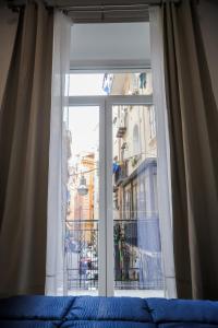 a bedroom window with a view of a city at Napolidays Rua Catalana Apartment in Naples