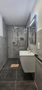 a bathroom with a shower and a tub and a sink at Gartenstudio Anila in Cochem