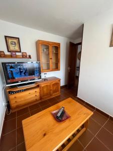 salon z telewizorem i drewnianym stołem w obiekcie Casa La Ranera de Santillana w mieście Santillana del Mar