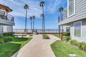 a walkway next to a house with palm trees at Bright Condo with Balcony, Steps to Oceanside Beach! in Oceanside