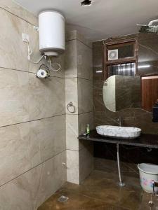 a bathroom with a sink and a mirror at Neewara Residency Apartment in Jaipur