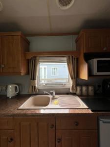 a kitchen counter with a sink and a window at Beautiful 2 bedroomed mobile home in Aberystwyth