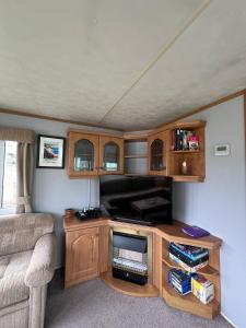 a living room with a tv and a couch at Beautiful 2 bedroomed mobile home in Aberystwyth