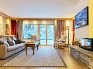a living room with a couch and a tv at Route de Tsarbouye 17, 4BR, Les Dauphinelles in Crans-Montana