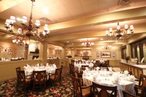 a dining room with white tables and chairs and chandeliers at Hotel Mead Resorts & Conventions Center in Wisconsin Rapids