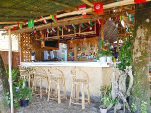 un bar con sillas y un mostrador con banderas en BH Beachfront Mini Glamping Tent, en El Nido