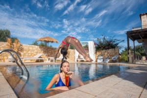 una mujer en el agua con una bebida en una piscina en Villa Sar, a Cretan Private Retreat, en Kambánion