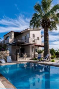 una casa con una palmera y una piscina en Villa Sar, a Cretan Private Retreat, en Kambánion