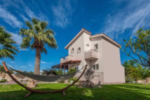 una casa con una hamaca delante en Villa Sar, a Cretan Private Retreat, en Kambánion