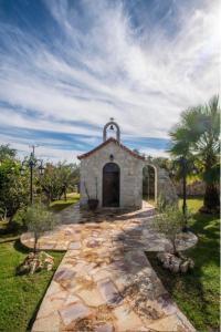 una pequeña capilla en un jardín con cielo en Villa Sar, a Cretan Private Retreat, en Kambánion