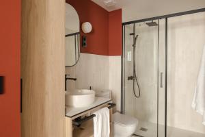 a bathroom with a toilet and a sink and a shower at Líbere Bilbao Ledesma in Bilbao