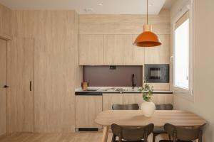 a kitchen and dining room with a wooden table and chairs at Líbere Bilbao Ledesma in Bilbao