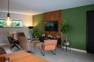 een woonkamer met groene muren en een tafel en stoelen bij Hotel B&B Buiten Loon in Loon op Zand