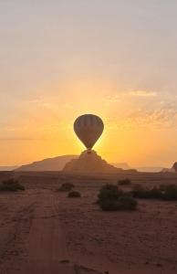 a hot air balloon in the desert at sunset at Wadi Rum Nabatean Camp in Wadi Rum