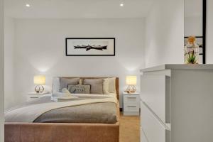a bedroom with a bed and two night stands at Modern Apartments close to Colombia Road Flower Market in London