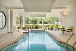una piscina con sedie e tavoli in un edificio di SpringHill Suites Ewing Township Princeton South a Ewing