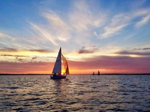 a sail boat in the water at sunset at Restaurants, Bars, Lake & Trails near DFW Airport in Flower Mound