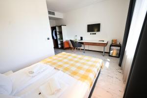 a bedroom with a bed and a desk and a table at RUBO Hotel in Shumen +64 photos