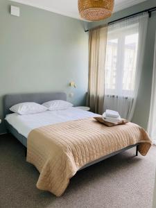 um quarto com uma cama com um cobertor e uma janela em Apartament Szczerbowskiego A em Lublin