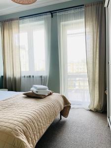 um quarto com uma cama e 2 janelas grandes em Apartament Szczerbowskiego A em Lublin