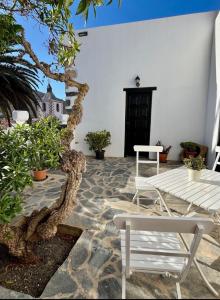 a patio with a white bench and some plants at Casa Doña Carmen in Betancuría