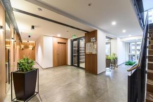 an office lobby with a staircase and potted plants at B-Holiday Luxury Apartments Urban Plaza in Braşov