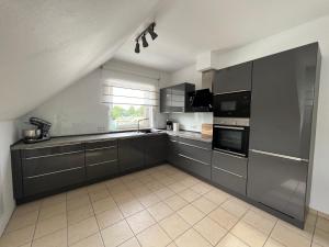 a large kitchen with gray cabinets and appliances at Camp Marina Ribbrock in Waltrop