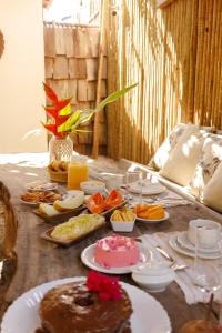 uma mesa com muitos pratos de comida em Encanto Caraíva em Caraíva