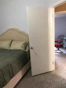une porte menant à une chambre avec un lit et une chaise dans l'établissement Summer Stop, à Eugene
