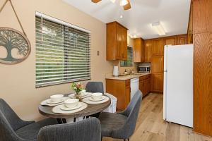 een keuken met een tafel en stoelen en een witte koelkast bij Charming 2 Room La Mesa Casita w/ Pool, BBQ & Yard in La Mesa