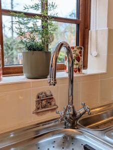 a kitchen sink with a faucet and a window at Strawberry Cottage Close RSPB and Wild Ken Hill - Crabpot Cottages Sheringham in Snettisham