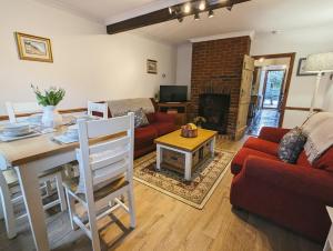 a living room with a red couch and a table at Strawberry Cottage Close RSPB and Wild Ken Hill - Crabpot Cottages Sheringham in Snettisham