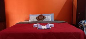 Una cama roja con una bata encima. en Goa tour advisor & hospitality, en Candolim