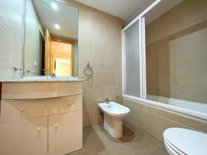 a bathroom with a toilet and a sink and a mirror at Oropesa Ciudad de Vacaciones 3000 in Oropesa del Mar