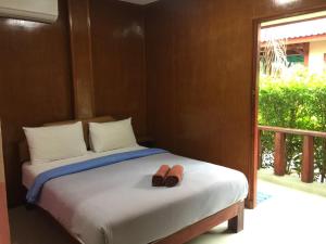 a bed with two pairs of shoes sitting on it at Ruen Nam Khoa Resort -Klongthom Krabi in Khlong Thom