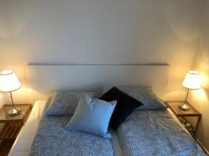 ein Schlafzimmer mit einem Bett mit zwei Kissen und zwei Lampen in der Unterkunft Great 1 bedroom apartment in Lidingö in Kottla
