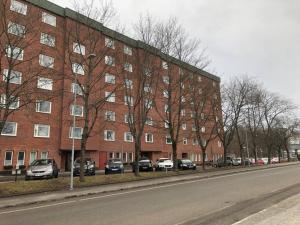 a large brick building with cars parked in front of it at Great 1 bedroom apartment in Lidingö in Kottla