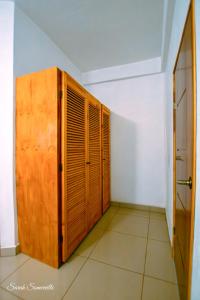 um quarto com um armário de madeira e uma porta em 1 Large beautiful poolside condo with AC! Great Location! em Carrillo