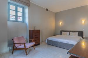 1 dormitorio con 1 cama, 1 silla y 1 mesa en Stylish Retro Suites, en Floriana