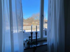 a window with two candles on a window sill at Spacious 1 bedroom flat, Lidingo in Kottla